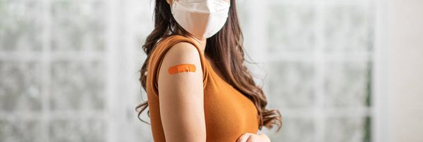 Banner of Woman wear medical face mask received anti virus vaccine cheerful with bandage,young woman enjoying and confident with future safety life after got COVID-19 vaccination,vaccination Concept - Photo, Image