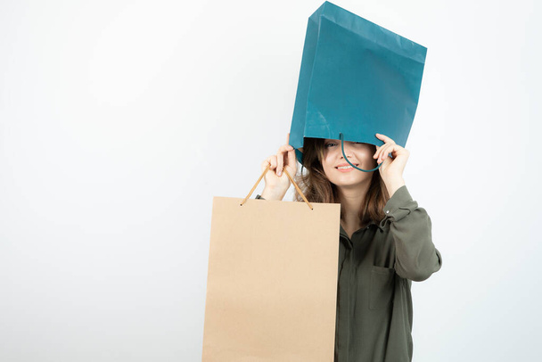 Image of young girl getting her head inside of craft bag. High quality photo - Photo, Image