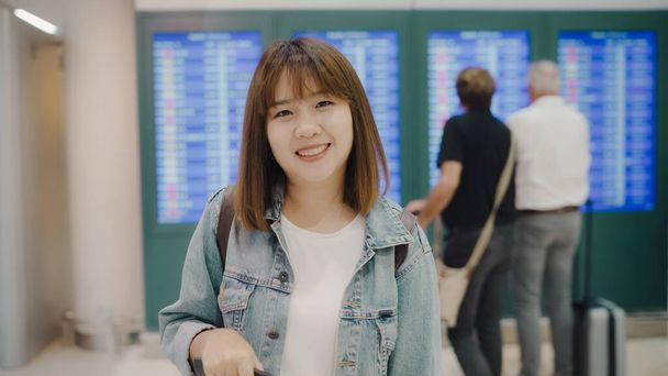 Щасливі азіатські жінки посміхаючись камеру під час перебування на термінал у міжнародному аеропорту, жіночий туристичних готовий поїхати у відпустку. Спосіб життя жінок зі святом в аеропорту концепції. - Фото, зображення