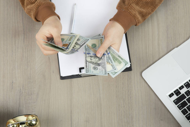 Üzletember kezei számolják a pénzt és jegyzetelnek az irodai asztalon. Kiváló minőségű fénykép - Fotó, kép