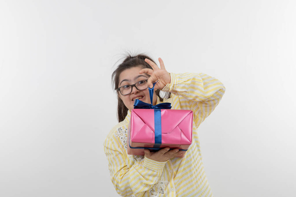 chica con síndrome de Down posando con caja de regalo - Foto, Imagen