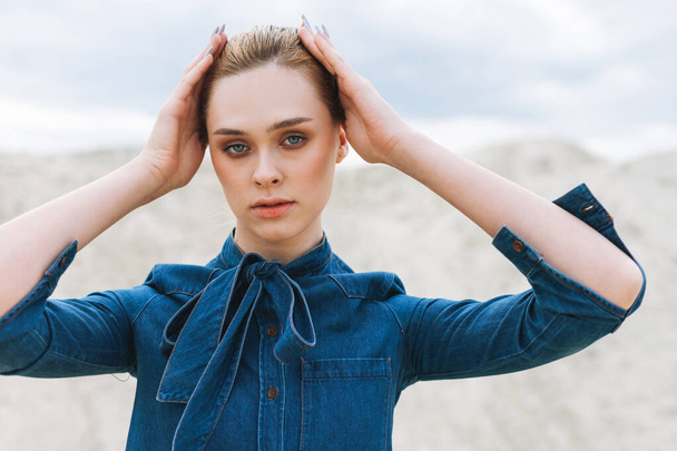 Fashion beauty portrait of young woman in blue organic denim shirt on desert background - Фото, зображення