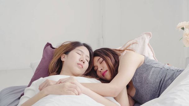 asiatische lesbische lgbtq Frauen Paar wachen zu Hause auf. junge asiatische Liebhaberin weiblich glücklich entspannen Ruhe zusammen nach dem Schlafen die ganze Nacht auf dem Bett, während auf dem Bett im Schlafzimmer zu Hause am Morgen Konzept. - Foto, Bild