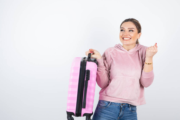 Imagen de una hermosa mujer con maleta de viaje rosa preparándose para las vacaciones. Foto de alta calidad - Foto, Imagen