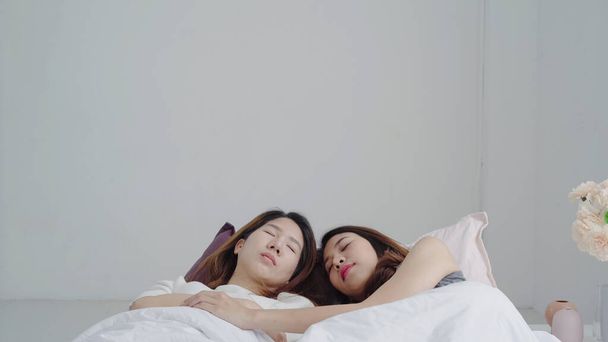 Asian Lesbian lgbtq women couple wake up at home. Young Asia lover female happy relax rest together after sleep all night on bed while lying on bed in bedroom at home in the morning concept. - Photo, Image
