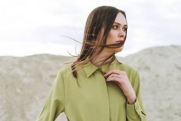 Retrato de beleza de moda de mulher jovem com cabelos longos em camisa orgânica verde no fundo do deserto - Foto, Imagem