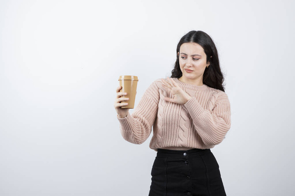 Portrait of pretty girl holding cup of drink against white wall. High quality photo - Photo, Image