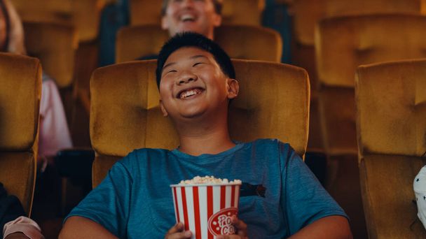 Beau jeune garçon asiatique joyeux riant tout en regardant un film au cinéma. Concept de divertissement Lifestyle. - Photo, image