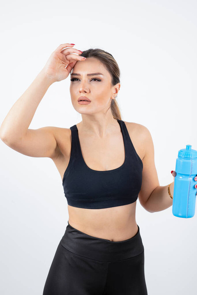 junge Frau in sportlicher Kleidung mit Wasserflasche - Foto, Bild