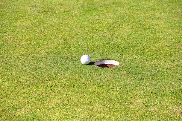 Golf ball on lip of cup - Foto, Imagem