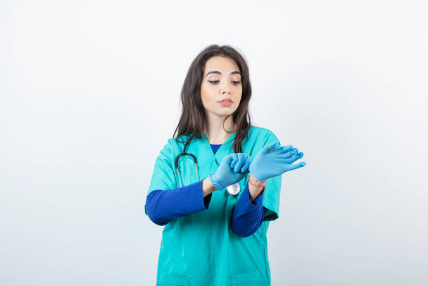 Portret van een jonge verpleegster met stethoscoop met medische handschoenen. Hoge kwaliteit foto - Foto, afbeelding