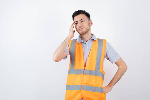 Portrait of young engineer in safety vest getting tired. High quality photo - 写真・画像