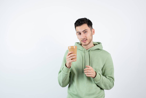 Молодой красивый мужчина с чашкой кофе, стоящей над белым. Высокое качество фото - Фото, изображение