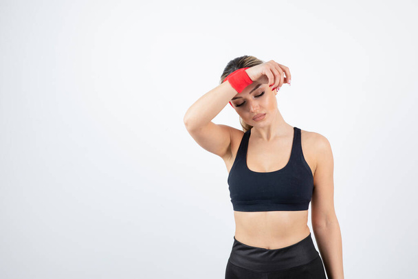 mooie jonge vrouw in sportieve kleding met rode hoofdband en polsbandje - Foto, afbeelding