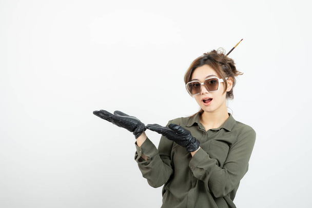Image of young adorable woman in glasses and black gloves standing. High quality photo - Φωτογραφία, εικόνα