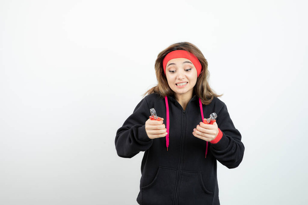 Fotka mladé sportovní dívky držící růžovou láhev vody. Kvalitní fotografie - Fotografie, Obrázek
