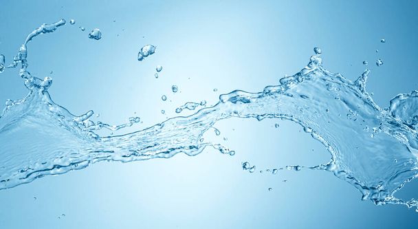 Всплеск воды изолирован на синем фоне - Фото, изображение