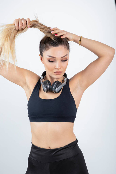 beautiful young woman in sportive clothes posing with headphones on neck - Фото, зображення