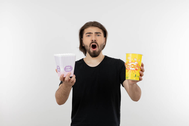 Photo of bearded man holding buckets of popcorn. High quality photo - Valokuva, kuva