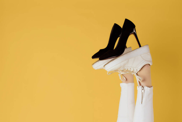 жіноче чорне взуття на інвертованих ногах жовтий фон
 - Фото, зображення