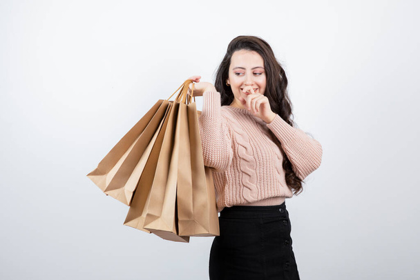 Muotokuva kaunis nainen villapaita tilalla paketteja pussit ostamisen jälkeen ostoksia. Laadukas kuva - Valokuva, kuva