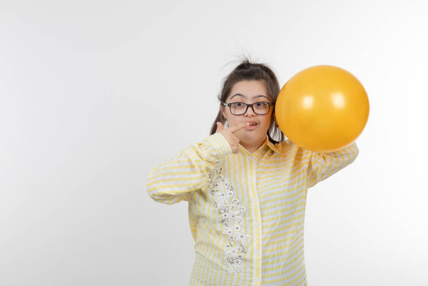 chica con síndrome de Down posando con globo - Foto, imagen