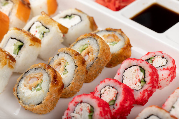 Assiette blanche de divers rouleaux de sushi savoureux vue rapprochée. Photo de haute qualité - Photo, image