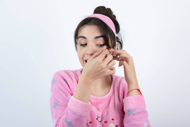 Foto de una joven en pijama con parches en los ojos. Foto de alta calidad - Foto, imagen