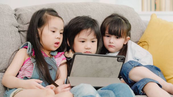 Grupo de niños que usan tabletas en el aula, niños y niñas multiétnicos felices usando la tecnología para estudiar y jugar juegos en la escuela primaria. Los niños utilizan la tecnología para el concepto educativo
. - Foto, Imagen