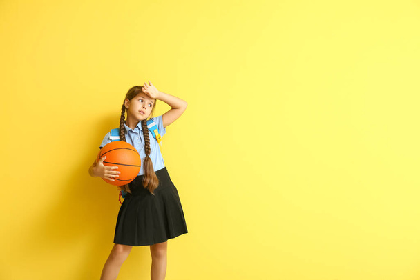 Écolière mignonne avec balle sur fond de couleur - Photo, image