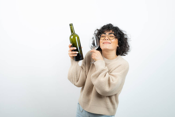 Temps de fête avec une brune aux cheveux courts tenant une bouteille de vin. Photo de haute qualité - Photo, image