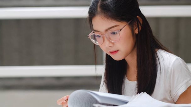 Asian student women reading books in library at university. Young undergraduate girl do homework, read textbook, study hard for knowledge and education on lecture desk at college campus. - Fotoğraf, Görsel