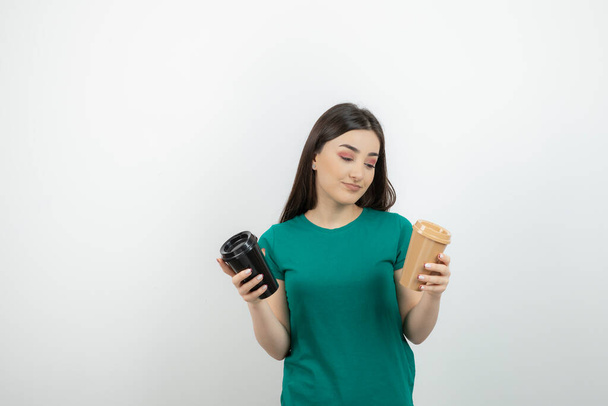 Foto di una bella donna in t-shirt blu con in mano caffè da asporto. Foto di alta qualità - Foto, immagini