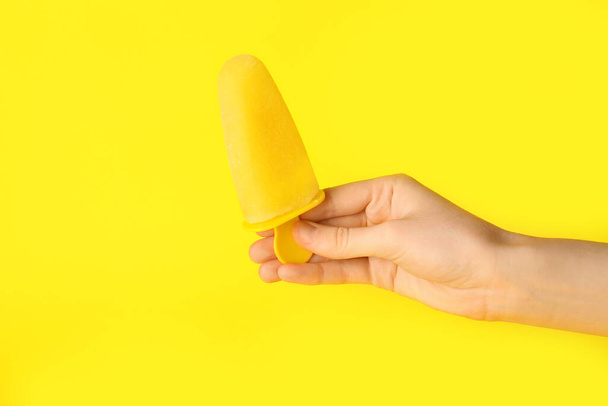 Female hand with tasty pineapple popsicle on color background - Φωτογραφία, εικόνα