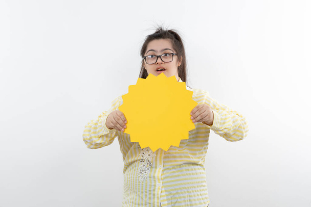 Mädchen mit Down-Syndrom posiert mit gelber Sonnenfigur - Foto, Bild