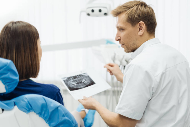 Dentist discussing with patient treatment plan - Photo, Image