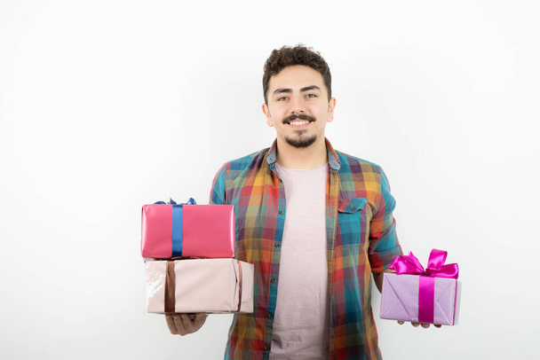 Portrait of an attractive man holding present boxes and looking at camera . High quality photo - Valokuva, kuva