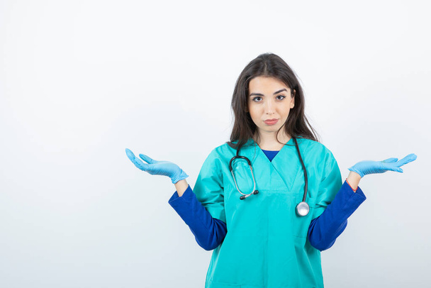 Retrato de enfermera joven con estetoscopio de pie en guantes médicos. Foto de alta calidad - Foto, imagen
