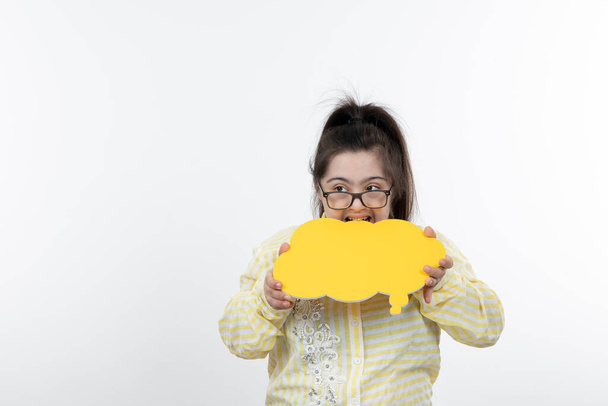 fille avec le syndrome du duvet posant avec du papier de coupe de bulle de parole jaune - Photo, image