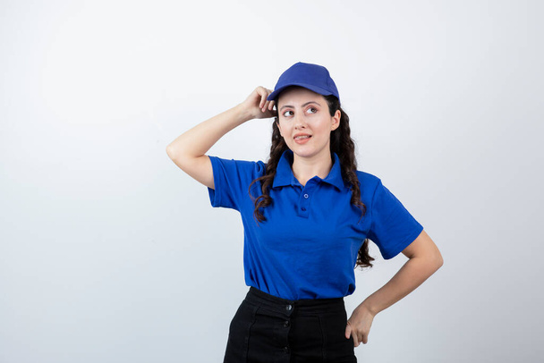 Una giovane donna in uniforme blu in piedi e in posa. Foto di alta qualità - Foto, immagini