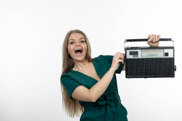 Obrázek krásné ženy s přenosným rádiovým přijímačem stojící nad bílou. Kvalitní fotografie - Fotografie, Obrázek