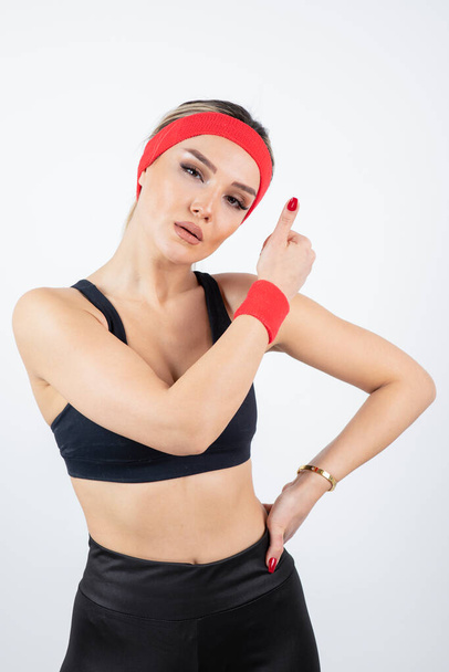 gyönyörű fiatal nő sportos ruhák piros fejpánt és csuklópánt - Fotó, kép