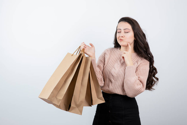 Retrato mulher bonita em camisola segurando sacos de pacotes com compras depois de fazer compras. Foto de alta qualidade - Foto, Imagem
