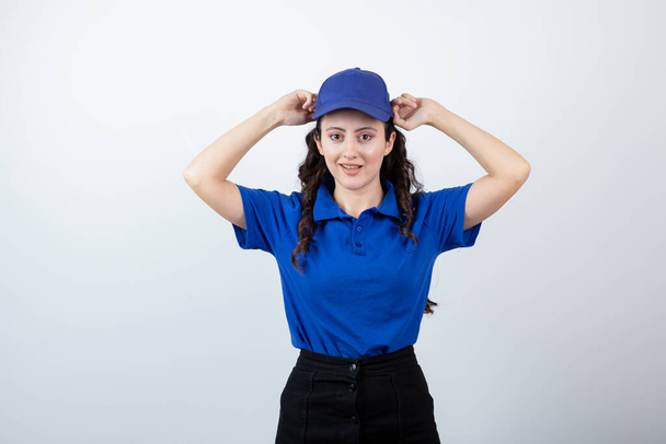 Una giovane donna in uniforme blu in piedi e in posa. Foto di alta qualità - Foto, immagini