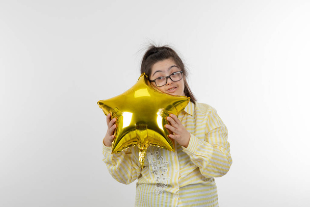 ragazza con sindrome di Down in posa con palloncino stella d'oro - Foto, immagini