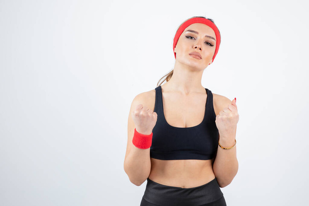 красивая молодая женщина в спортивной одежде с красным повязкой на голове и браслетом - Фото, изображение