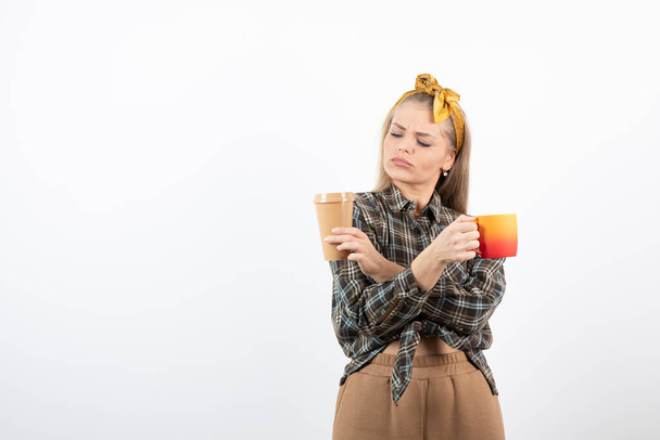 Portret młodej blondynki w opasce trzymającej filiżankę herbaty i kawy. Wysokiej jakości zdjęcie - Zdjęcie, obraz