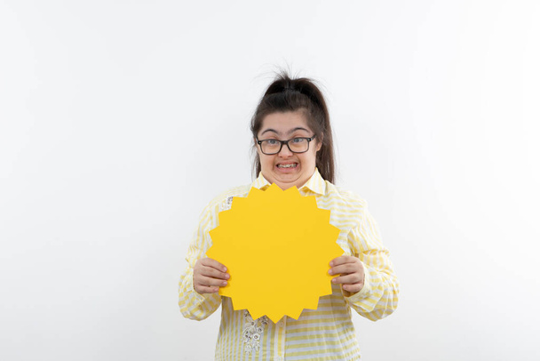 ragazza con sindrome di Down posa con figura gialla carta tagliata sole - Foto, immagini