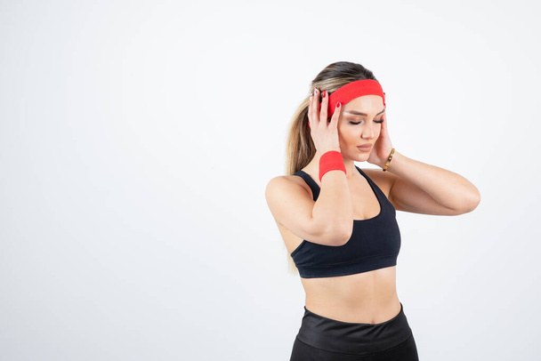 beautiful young woman in sportive clothes with red headband and wristband - Фото, зображення