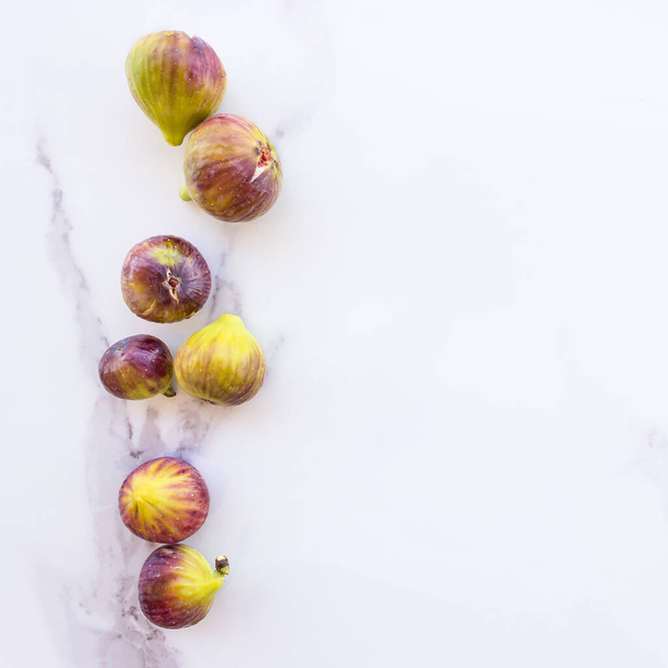 Figues fraîches mûres sur une table en pierre blanche. Concept alimentation saine, végétarisme, régime méditerranéen. Espace de copie - Photo, image